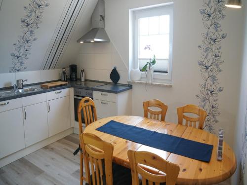 a kitchen with a wooden table and chairs in a kitchen at Ferienwohnung an der Au in Taarstedt