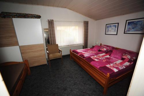 una camera da letto con un letto e una sedia di Ferienwohnung Frieda, 65207 a Moormerland