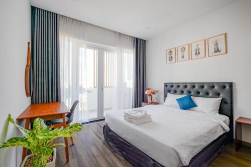 a bedroom with a bed and a desk and a window at Jomo in Ho Chi Minh City