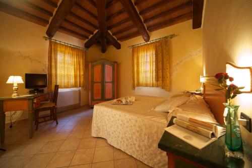 a bedroom with a bed and a desk with a computer at Agriturismo Il Felciaione in Massa Marittima