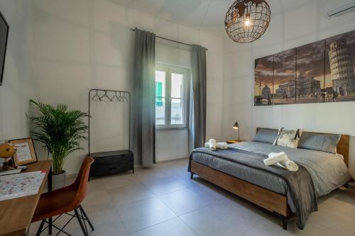 een slaapkamer met een bed, een tafel en een bureau bij Travel B&B in Pisa