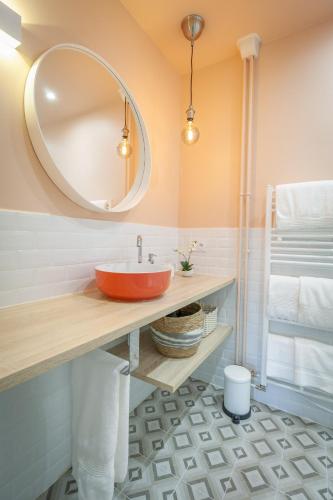 La salle de bains est pourvue d'un lavabo rouge et d'un miroir. dans l'établissement Mountain Suite, à Annecy