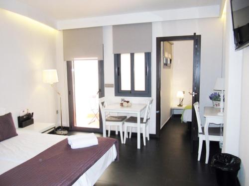 a hotel room with a bed and a table and chairs at Barcelona Fifteen central Aparthotel in Barcelona