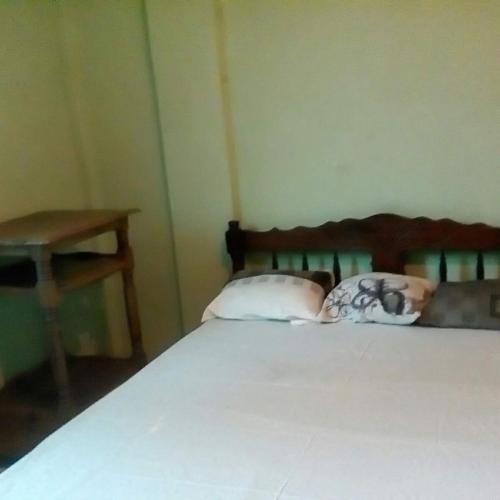 a bedroom with a bed with two pillows and a table at Appartement F2 50m2 centre ville sécurisé in Diego Suarez