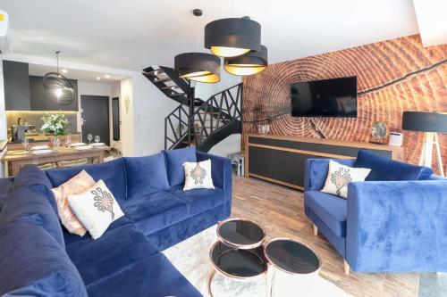 a living room with a blue couch and a tv at Apartamenty Marron z sauną, bawialnią i widokiem na Skrzyczne - Dream Apart in Szczyrk