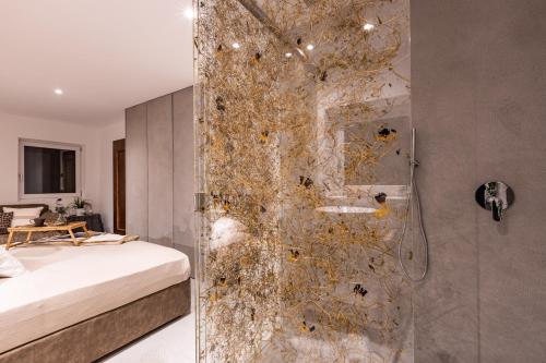 a bathroom with a shower with a sink and a bed at Luxury Wellness Lusiaski in Bellamonte