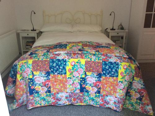 - un lit avec une couette colorée dans l'établissement River Walk, à Lyme Regis