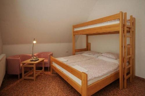 ein Schlafzimmer mit einem Etagenbett und einem Tisch mit einer Lampe in der Unterkunft Tradiční hostinec in Sněžné