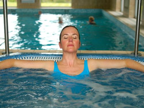 a woman is in a swimming pool at Penmere Manor Hotel in Falmouth