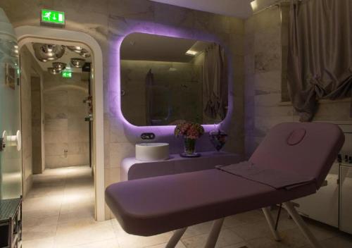 a purple bathroom with a sink and a mirror at Duchessa Isabella Hotel & SPA in Ferrara