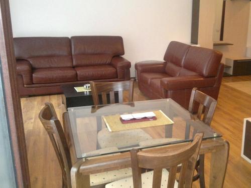 a living room with a glass table and a couch at Persey Flora Apartments in Borovets