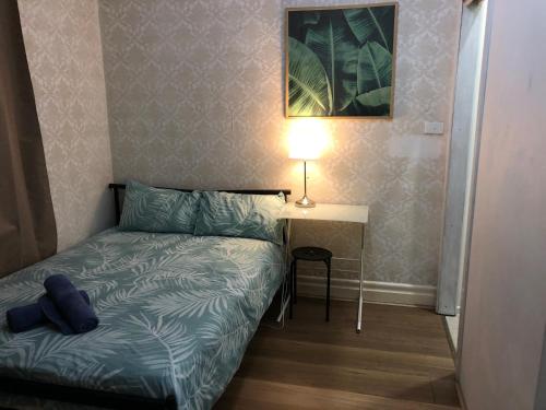a small bedroom with a bed and a table with a lamp at Melbourne short stay - Caulfield station, Monash Uni in Melbourne