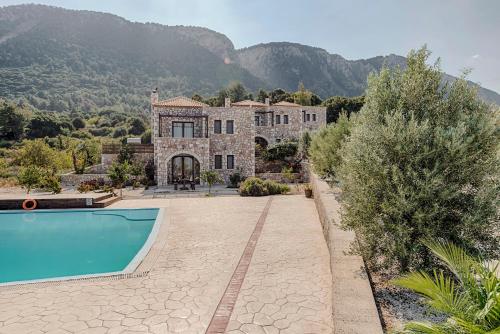 a house with a swimming pool in front of a mountain at Salakos Villas in Sálakos