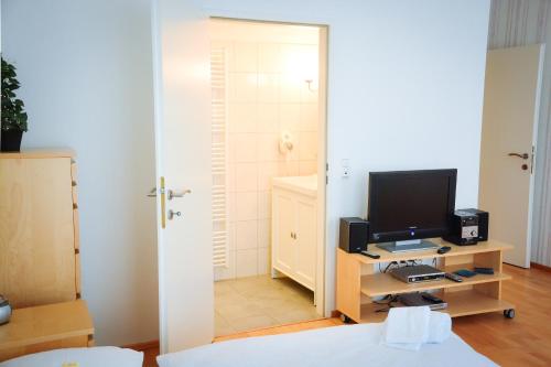 ウィーンにあるAugarten Residencesのテレビ、デスク、コンピュータが備わる客室です。