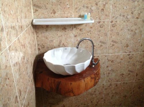 a bathroom with a bowl sink on a wooden stump at Ruan Mai Naiyang Beach Resort in Nai Yang Beach