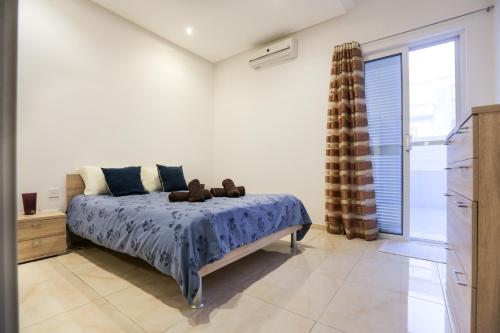 a bedroom with a bed with two teddy bears on it at Valletta Triton Apartment in Valletta