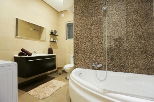 a bathroom with a tub and a toilet and a shower at Valletta Triton Apartment in Valletta