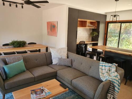 a living room with a couch and a table at Seacliff Park Holiday Home in Seacliff