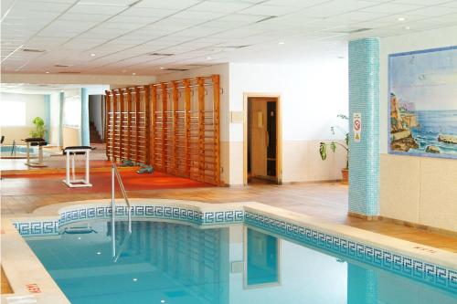 a large swimming pool in a building with a room with at Stil Bonsai in Can Picafort
