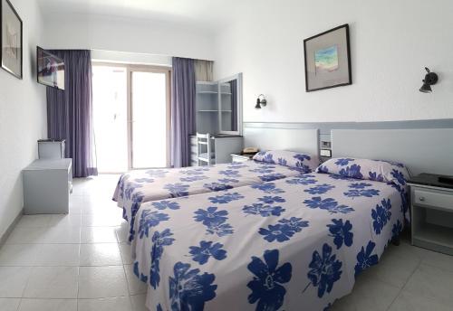 a bedroom with two beds with blue and white sheets at Stil Bonsai in Can Picafort