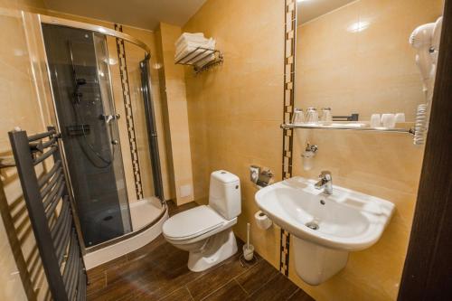 y baño con aseo, lavabo y ducha. en Hotel Europa en Liptovský Mikuláš