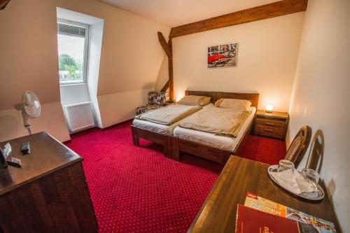 sypialnia z łóżkiem i czerwonym dywanem w obiekcie Hotel Europa w Liptowskim Mikulaszu