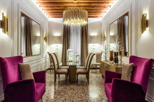 a salon with purple chairs and a table and a chandelier at Ca' Pagan in Venice