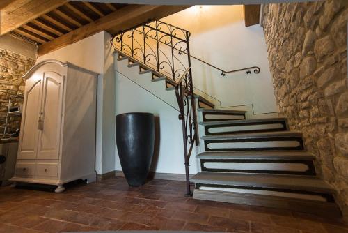 a spiral staircase in a room with a stone wall at AGRITURISMO Ca' Maggio in Sassofeltrio