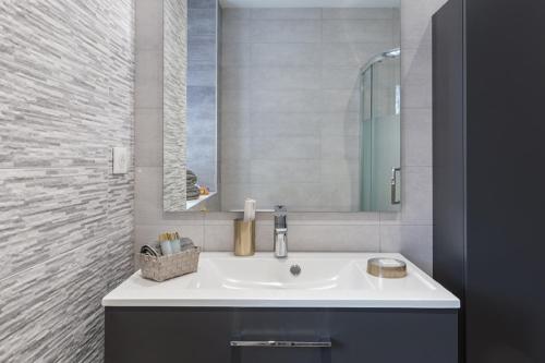 une salle de bain avec un lavabo et un miroir dans l'établissement SLEEP IN MULHOUSE, à Mulhouse
