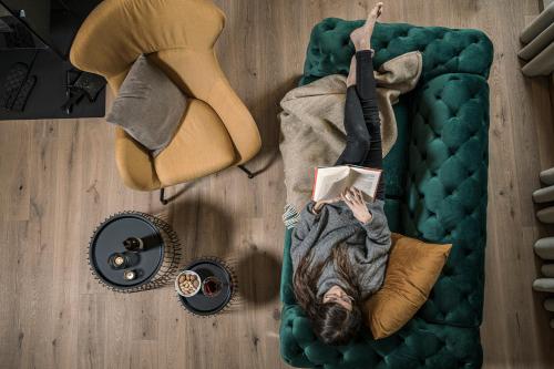 a man laying on a bed reading a book at Ramenai - Das Böhmerwaldlerdorf in Ulrichsberg
