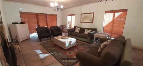 a living room with a couch and a table at Barton Luxury Villas in Botrivier