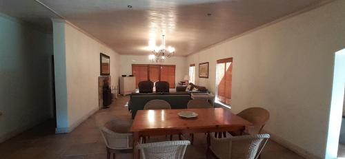 a dining room and living room with a table and chairs at Barton Luxury Villas in Botrivier