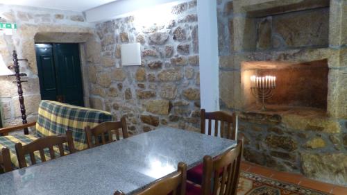 a dining room with a table and a stone wall at Casas do Toural in Gouveia
