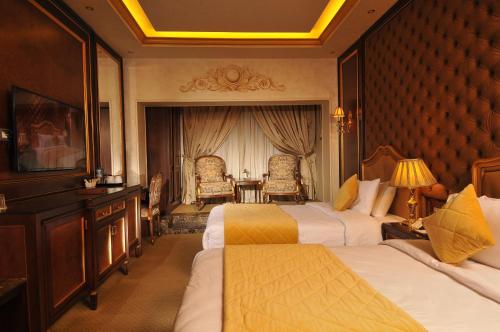 Golden Inn Hotel في القاهرة: غرفة فندقية بسريرين وطاولة