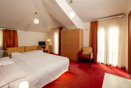 una camera d'albergo con letto, scrivania e finestra di Accademia Hotel a Rimini