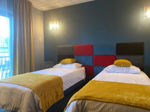 a room with two beds with colorful at Hotel Marta in Oława