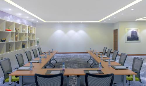 a conference room with tables and chairs and a wall at Wyndham Garden Muscat Al Khuwair in Muscat