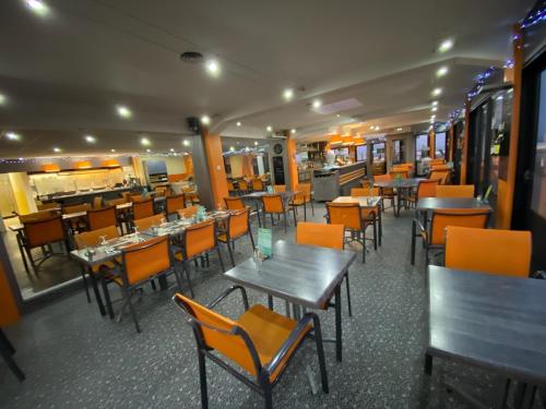 a dining room with tables and chairs in a restaurant at Hôtel De La Plage in Calais