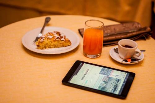 a table with a plate of cake and a cup of orange juice at Albergo Birra in Savignone