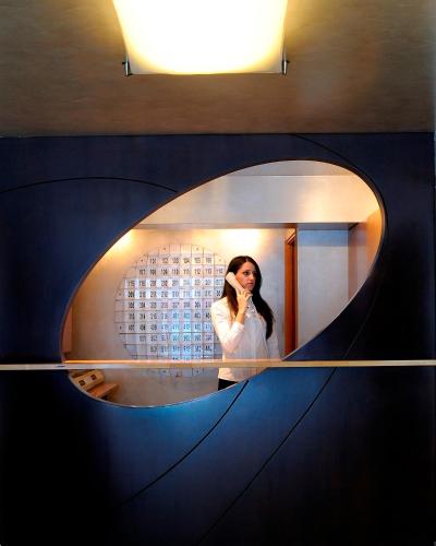 a woman talking on a cell phone in front of a mirror at Maniatis Hotel in Sparti