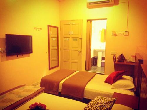 a hotel room with two beds and a mirror at Weng Kong Hotel in Slim River