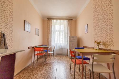 a kitchen with a table, chairs and a refrigerator at Hostel Dakura in Prague