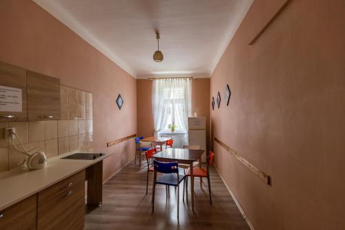 een keuken met een tafel en stoelen in een kamer bij Hostel Dakura in Praag