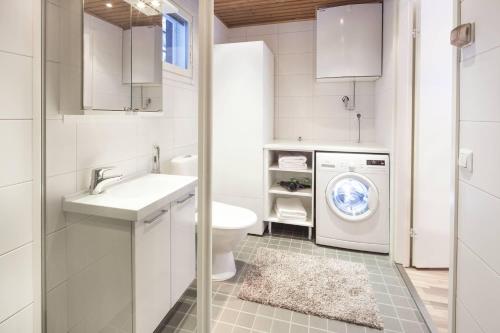 y baño con lavadora, lavadora y secadora. en Holiday Club Kuusamon Tropiikki Apartments, en Kuusamo