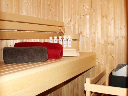 a wooden shelf in a sauna with bottles and towels at Mien Dröm im Sielhuus in Butjadingen