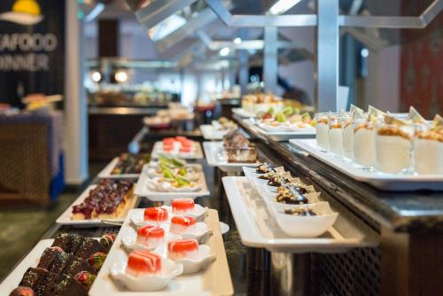 un buffet avec de nombreux desserts différents dans l'établissement Aquila Elounda Village Resort, Suites & Spa, à Elounda