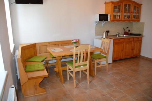 a kitchen with a wooden table and chairs in a kitchen at Penzion U podkováře in Třeboň