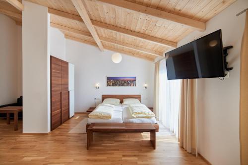 a bedroom with a bed and a flat screen tv at Hotel Gasthof-Strasser in Tumeltsham