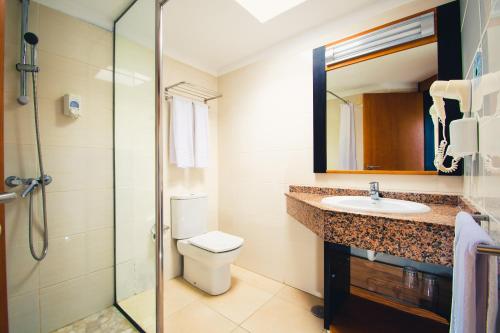 a bathroom with a toilet and a sink and a shower at HL Miraflor Suites Hotel in Playa del Ingles