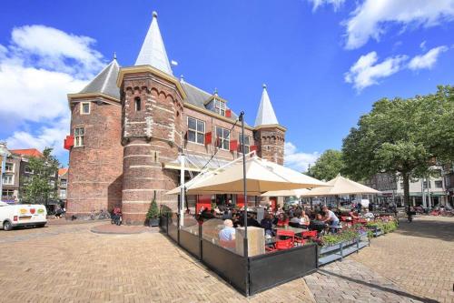 een groep mensen die aan tafels voor een gebouw zitten bij The Hotel Apartments in the Center of Amsterdam in Amsterdam